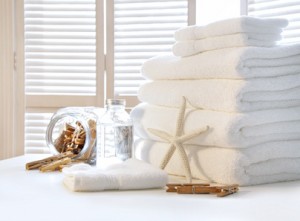 Fluffy white towels on table with shutter door